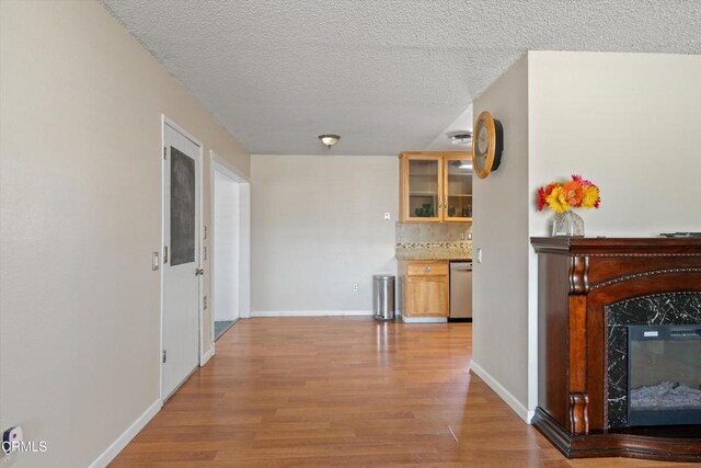 1037 Cortina Ct, Orland, CA 95963 - unfurnished living room featuring light wood-style floors, baseboards, a fireplace, and a textured ceiling