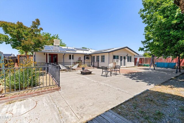 1037 Cortina Ct, Orland, CA 95963 - back of house featuring an outdoor fire pit, a patio, solar panels, and a fenced backyard