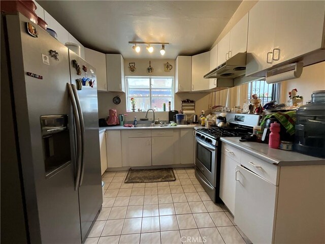 4320 Rio Hondo Ave, Rosemead, CA 91770 - kitchen featuring appliances with stainless steel finishes, under cabinet range hood, a sink, light tile patterned floors, and white cabinets