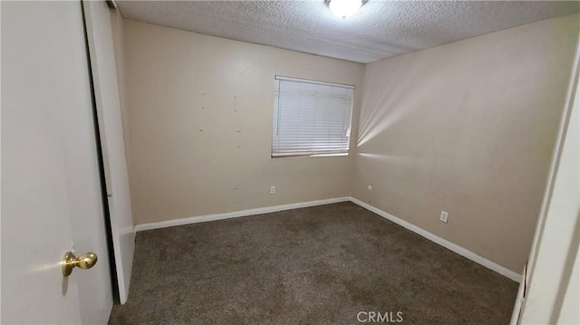 unfurnished room featuring carpet floors, a textured ceiling, and baseboards