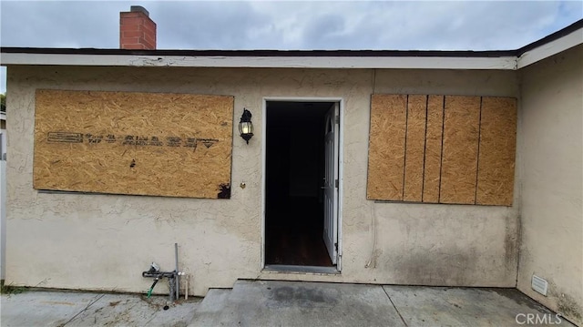 property entrance with stucco siding