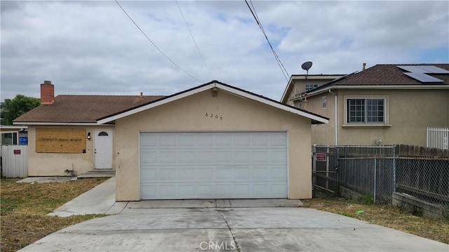 view of front of property with stucco siding, concrete driveway, a garage, fence, and a chimney