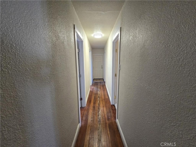 621 Colusa St, Orland, CA 95963 - hall featuring a textured wall, hardwood / wood-style flooring, baseboards, and a textured ceiling