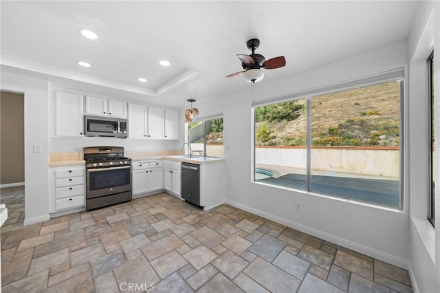 39812 Barcelona, Murrieta, CA 92562 - kitchen with stainless steel appliances, light countertops, white cabinetry, baseboards, and recessed lighting