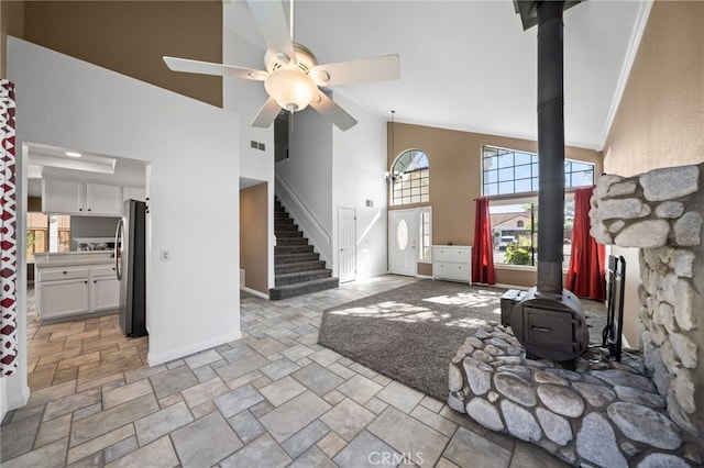 39812 Barcelona, Murrieta, CA 92562 - living area with a wood stove, high vaulted ceiling, stone tile floors, baseboards, and ceiling fan