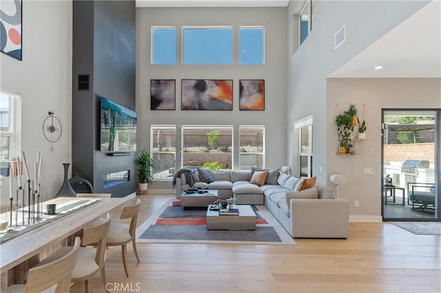 living room with a high ceiling, wood finished floors, and baseboards