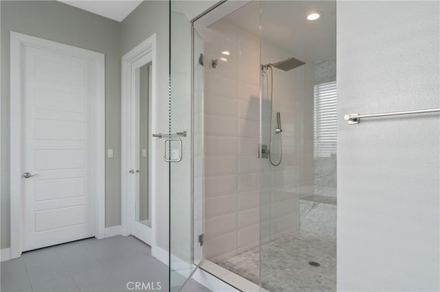 full bathroom featuring a shower stall, tile patterned floors, and baseboards