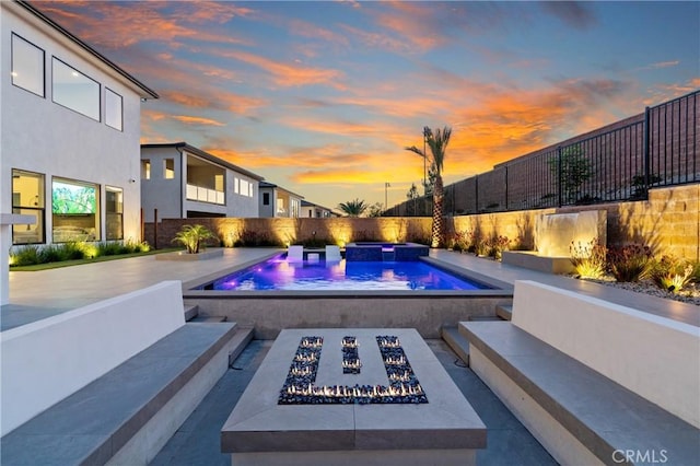 view of swimming pool featuring a fire pit, fence, and an in-ground hot tub