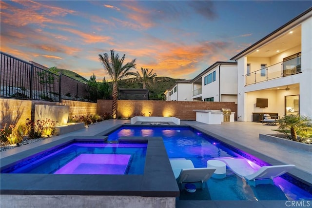 view of pool with area for grilling, a patio area, a fenced backyard, and a pool with connected hot tub