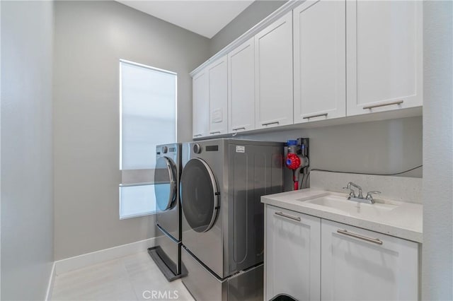 laundry room featuring washer and dryer, cabinet space, and baseboards