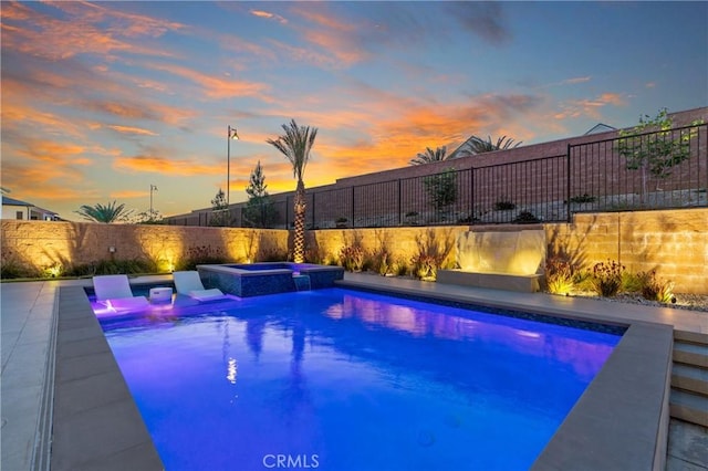 view of swimming pool featuring a fenced backyard and a pool with connected hot tub