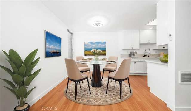 dining space with light wood-style floors and baseboards