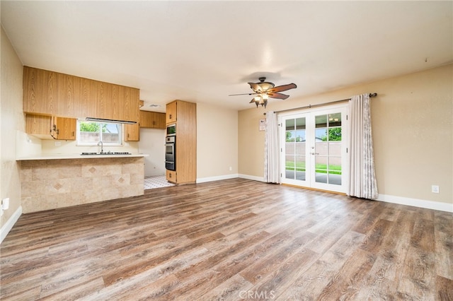 6329 Fillmore Ave, Rialto, CA 92377 - kitchen featuring light countertops, a peninsula, wood finished floors, ceiling fan, and a sink