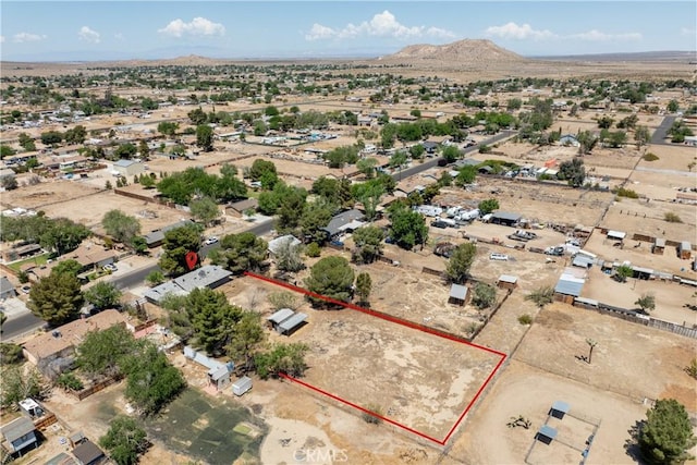aerial overview of property's location with a mountainous background, property boundaries highlighted, and a desert landscape