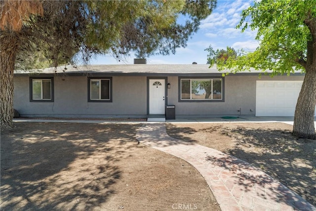 ranch-style home with a garage and stucco siding