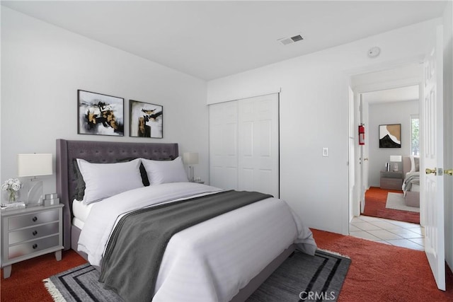 bedroom featuring carpet flooring, a closet, and tile patterned floors