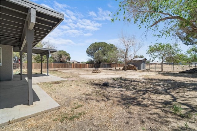 fenced backyard with a fire pit, a patio area, a storage shed, and an outdoor structure