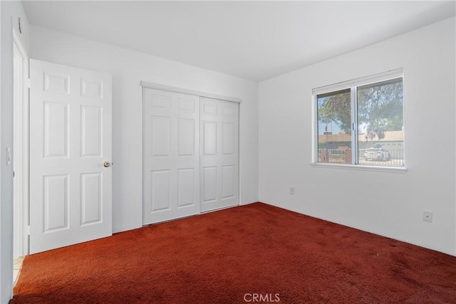 unfurnished bedroom with carpet flooring and a closet
