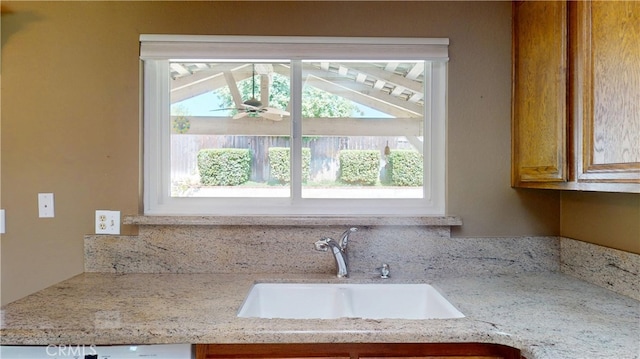 279 White Oak Rd, Lake Elsinore, CA 92530 - kitchen with a sink, ceiling fan, brown cabinets, and light stone counters
