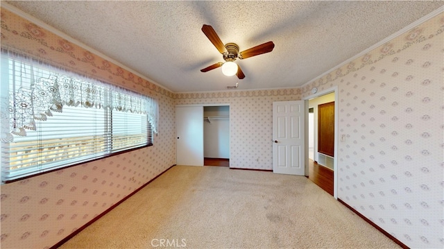 279 White Oak Rd, Lake Elsinore, CA 92530 - unfurnished bedroom with ornamental molding, wallpapered walls, a textured ceiling, a closet, and carpet flooring