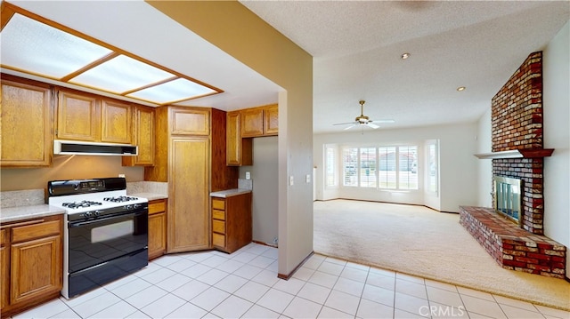 279 White Oak Rd, Lake Elsinore, CA 92530 - kitchen with range with gas stovetop, under cabinet range hood, light carpet, ceiling fan, and light countertops