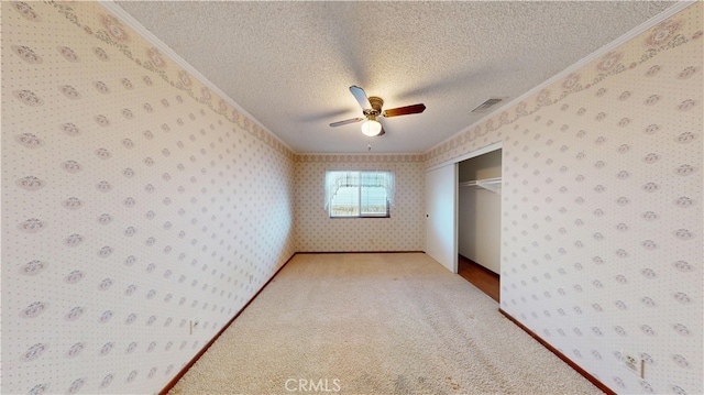 279 White Oak Rd, Lake Elsinore, CA 92530 - unfurnished bedroom featuring wallpapered walls, ornamental molding, a textured ceiling, a closet, and carpet flooring