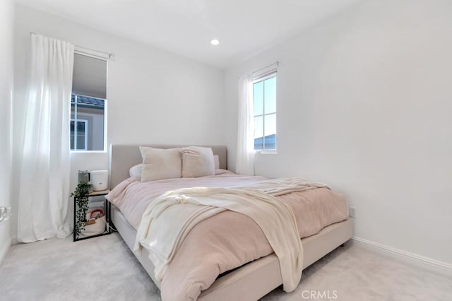 bedroom with light carpet and baseboards