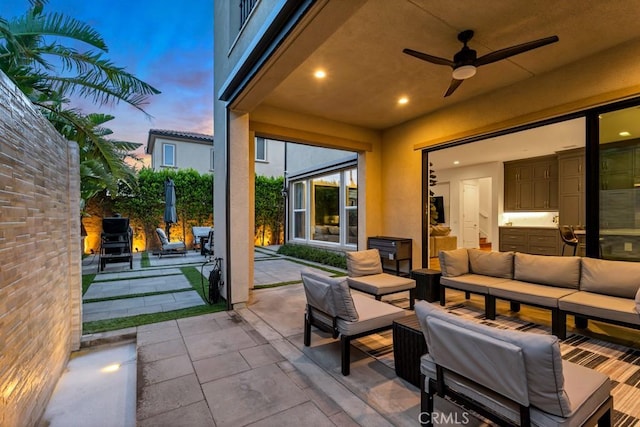 patio terrace at dusk with an outdoor hangout area and ceiling fan