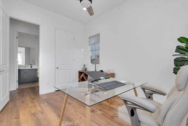 home office with ceiling fan and light wood-type flooring