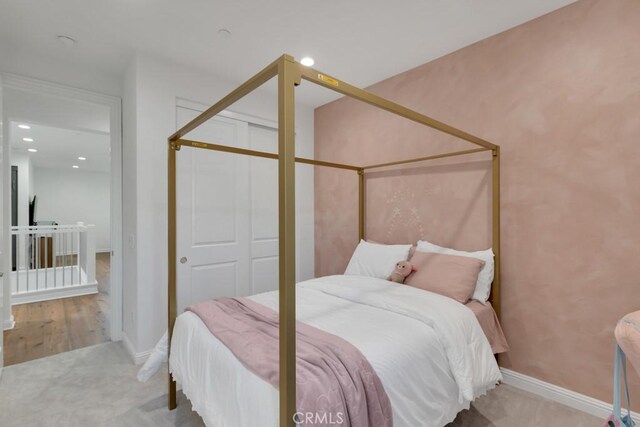 bedroom with recessed lighting, a closet, baseboards, carpet flooring, and wood finished floors