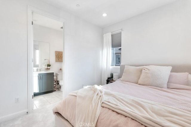 bedroom with ensuite bath, recessed lighting, light colored carpet, light tile patterned floors, and baseboards