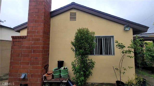 view of home's exterior with stucco siding and a chimney