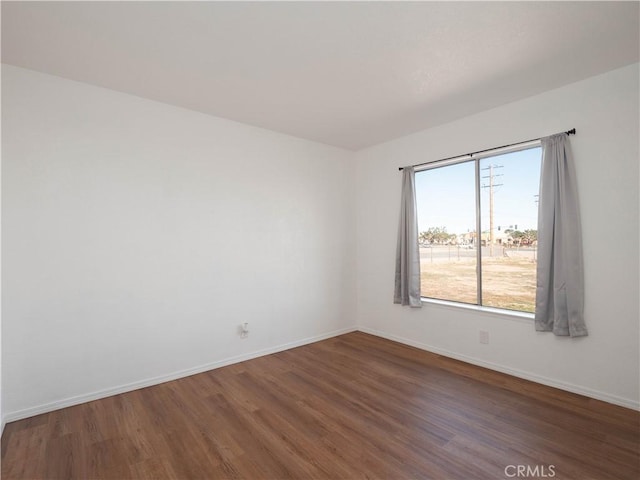 empty room featuring wood finished floors and baseboards