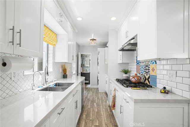 1742 Dixon St, Redondo Beach, CA 90278 - kitchen with under cabinet range hood, stainless steel appliances, a sink, white cabinetry, and tasteful backsplash