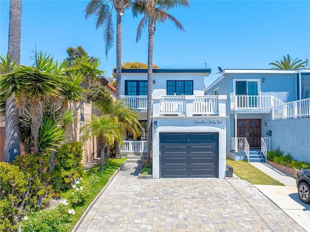 1742 Dixon St, Redondo Beach, CA 90278 - view of front of house featuring stucco siding, a balcony, decorative driveway, a garage, and french doors