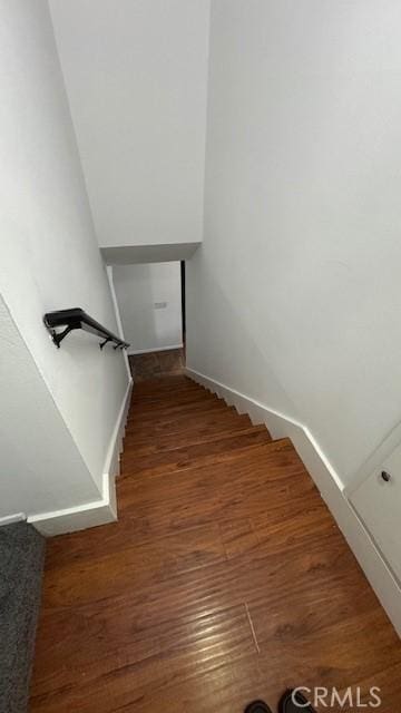 staircase with baseboards and wood finished floors
