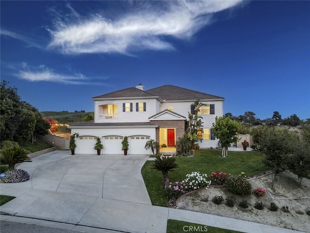 traditional home with concrete driveway, an attached garage, a front lawn, and a chimney