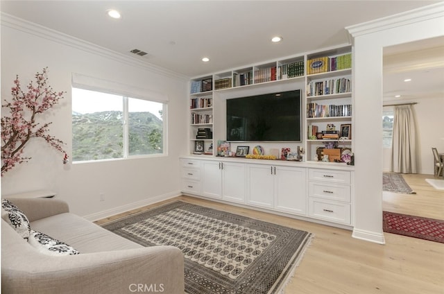 living area featuring light wood-style floors, ornamental molding, baseboards, and recessed lighting