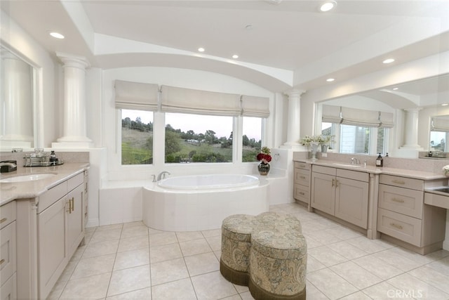 full bath featuring ornate columns, a garden tub, recessed lighting, tile patterned floors, and two vanities