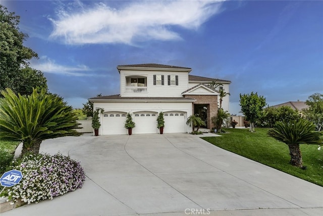 traditional-style home featuring a garage, a front yard, driveway, and a balcony