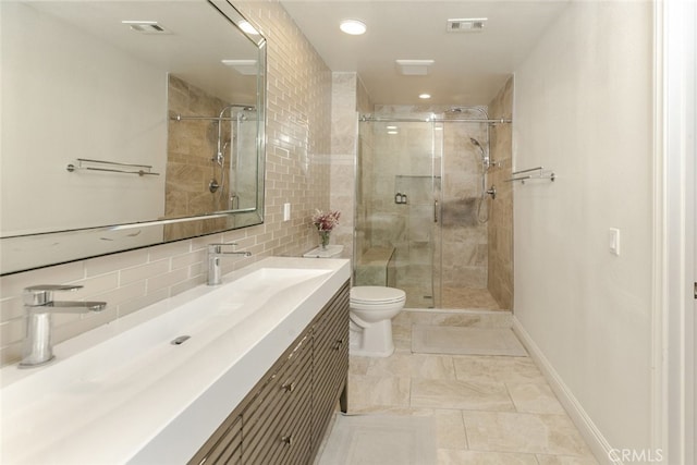 bathroom featuring toilet, a stall shower, vanity, recessed lighting, and decorative backsplash