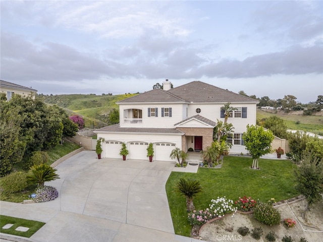 traditional-style home featuring driveway, a garage, and a chimney