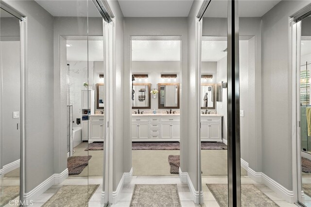 bathroom with double vanity and baseboards