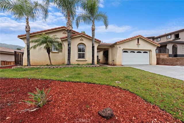 mediterranean / spanish house with an attached garage, stucco siding, concrete driveway, and a tile roof