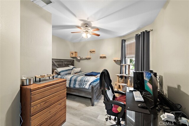 bedroom with light wood-style flooring, an office area, and ceiling fan