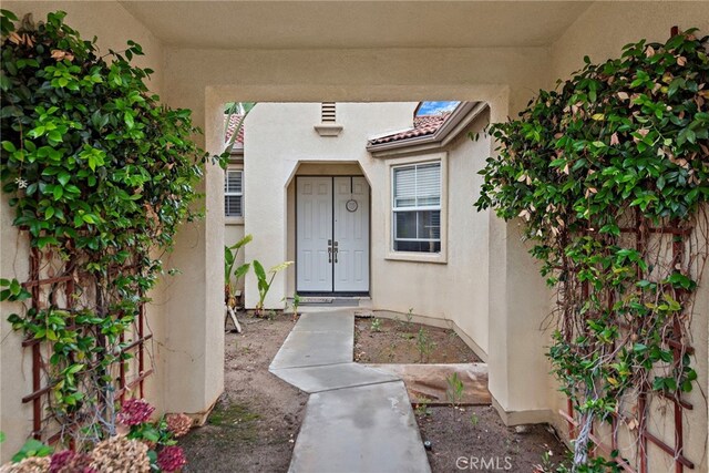 entrance to property featuring stucco siding