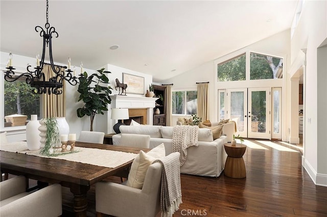 dining room featuring a chandelier, dark wood finished floors, french doors, high vaulted ceiling, and a fireplace
