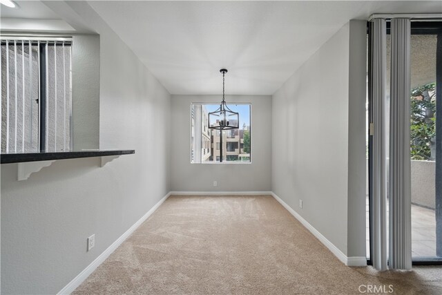 7826 Topanga Canyon Blvd Unit 218, Canoga Park, CA 91304 - spare room featuring carpet floors, a chandelier, healthy amount of natural light, and baseboards
