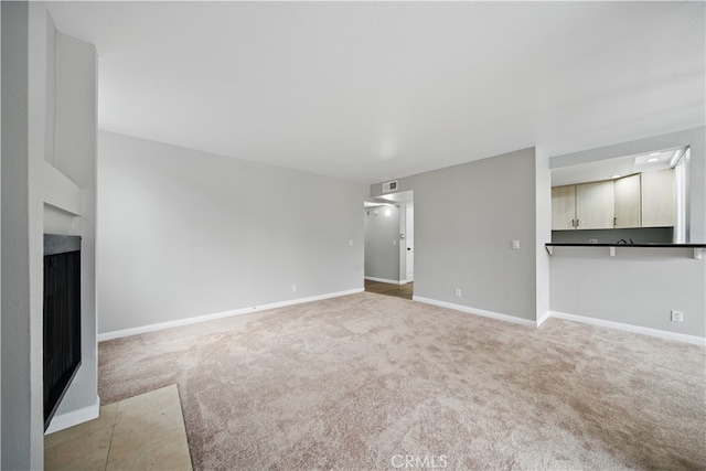 7826 Topanga Canyon Blvd Unit 218, Canoga Park, CA 91304 - unfurnished living room with light colored carpet, baseboards, and a fireplace
