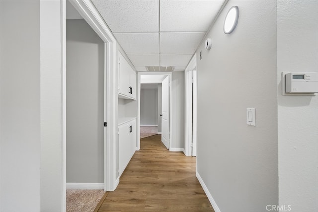 7826 Topanga Canyon Blvd Unit 218, Canoga Park, CA 91304 - hall featuring a paneled ceiling, light wood finished floors, and baseboards